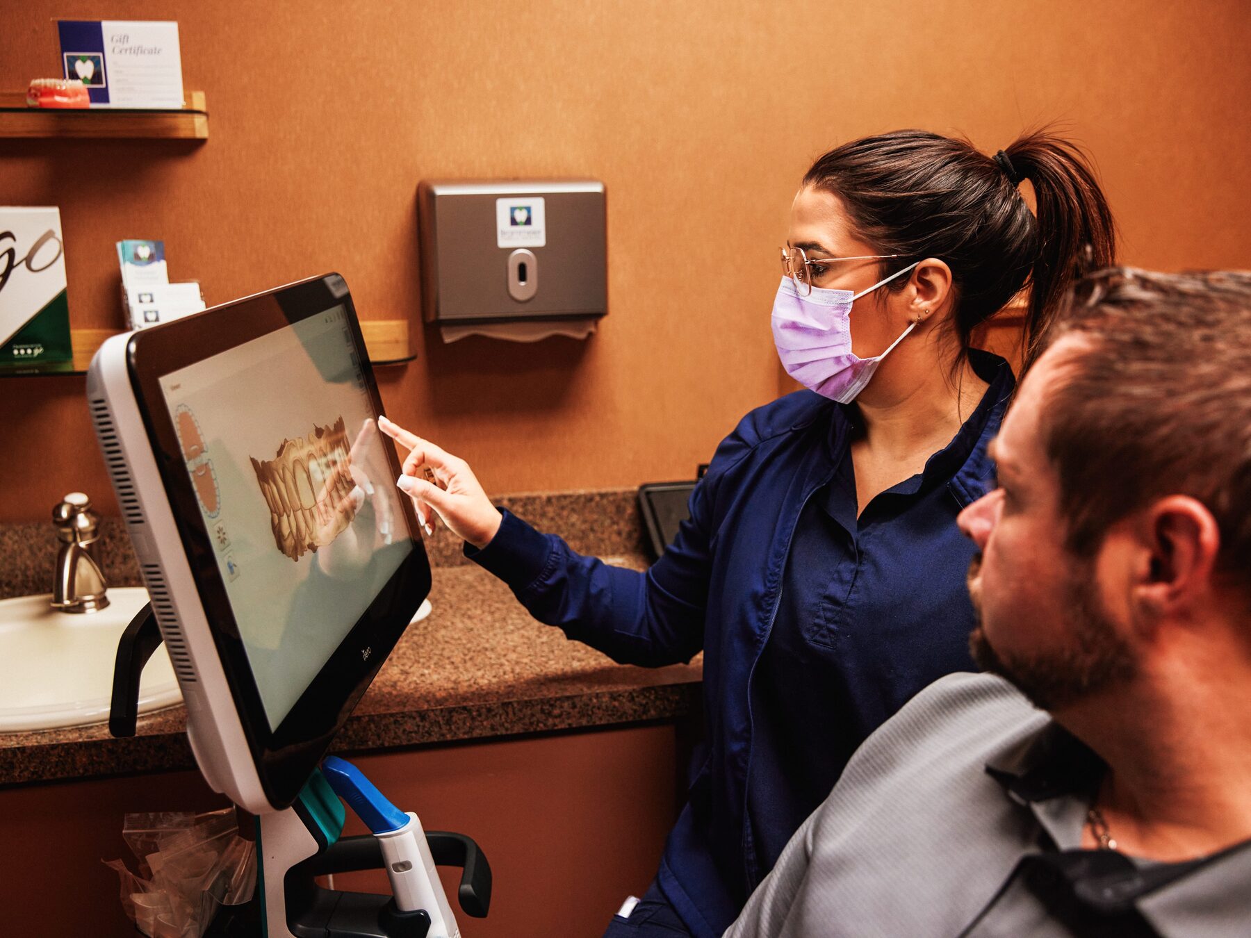 Dental assistant showing intraoral scan results to a patient